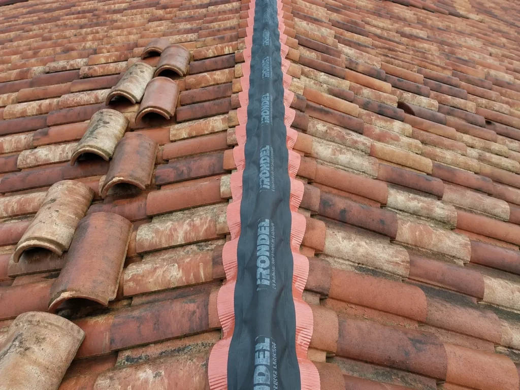 Pose d'un nouveau closoir ventilé lors d'une rénovation de faîtage réalisée par IT Rénovation