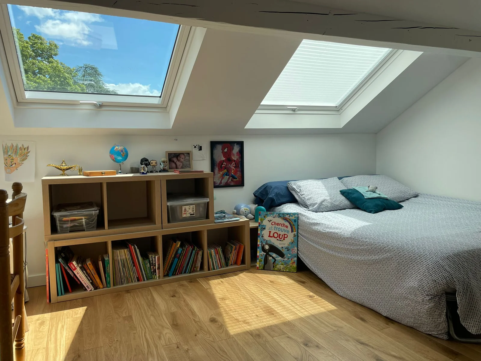 Aménagement de combles avec deux fenêtres de toit VELUX apportant une lumière naturelle abondante dans une chambre en Isère