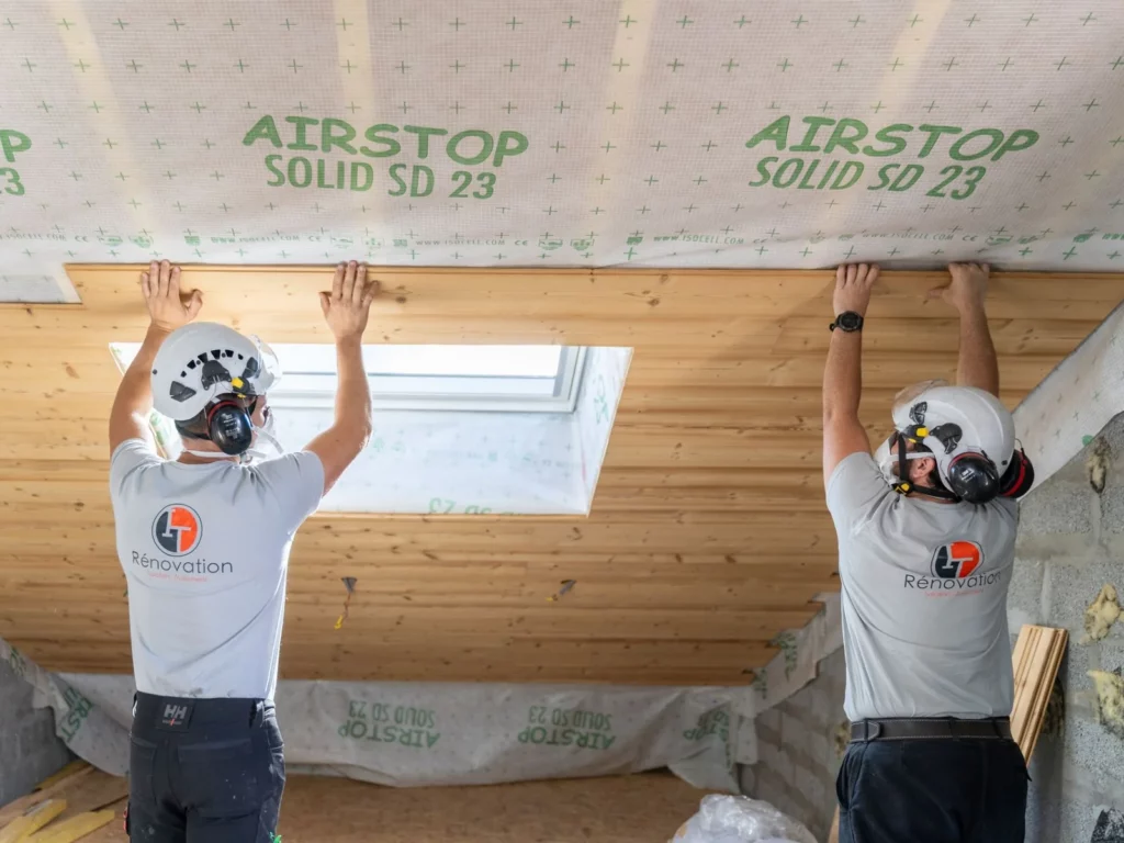 Finition intérieure en lambris bois autour d'une fenêtre de toit VELUX lors d'un aménagement de combles